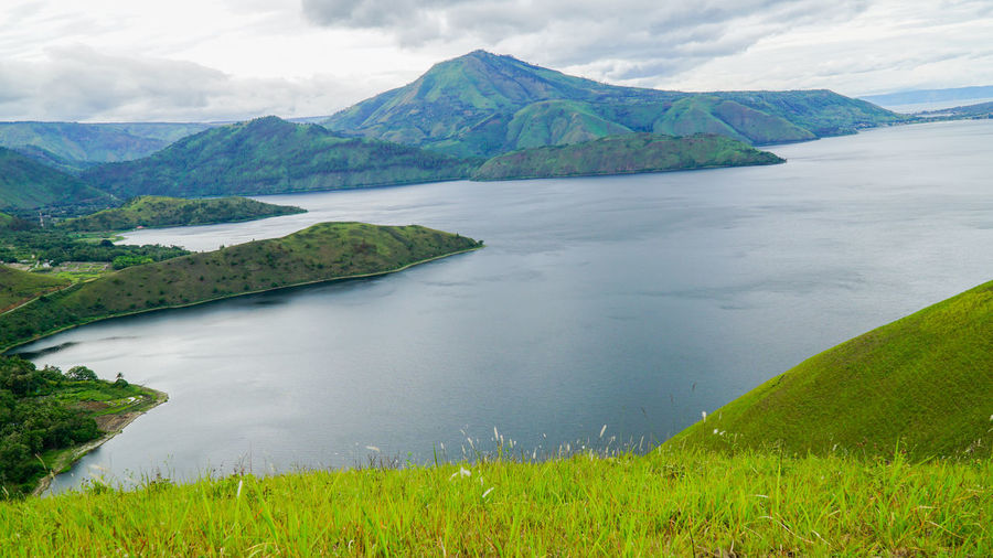 Scenic view of lake by mountains against sky