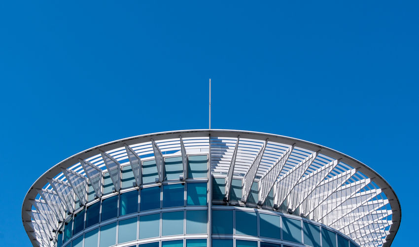 Low angle view of modern building against clear blue sky
