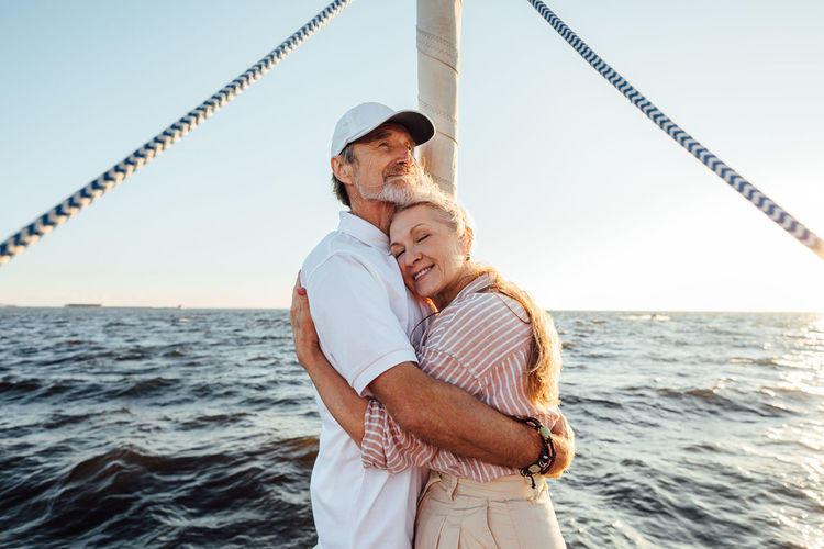 Smiling senior couple standing at boat