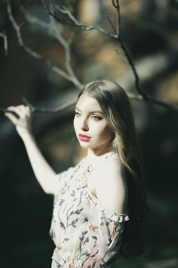 Beautiful young woman looking away while standing outdoors
