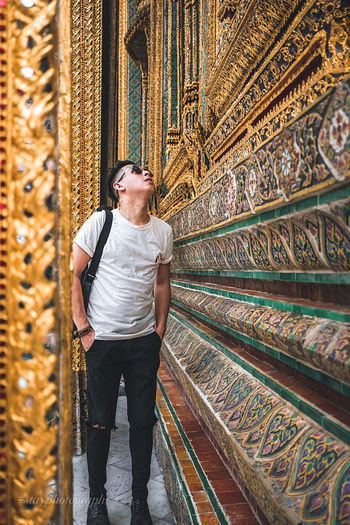 Full length of young man looking up while standing in temple