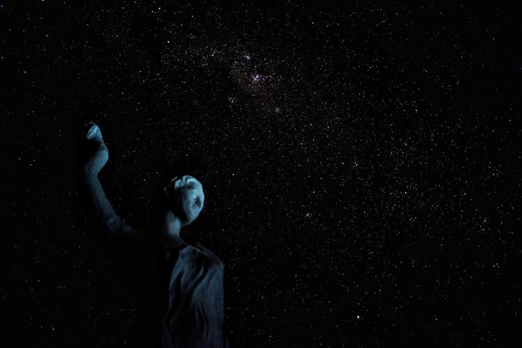 Low angle view of statue against star field at night