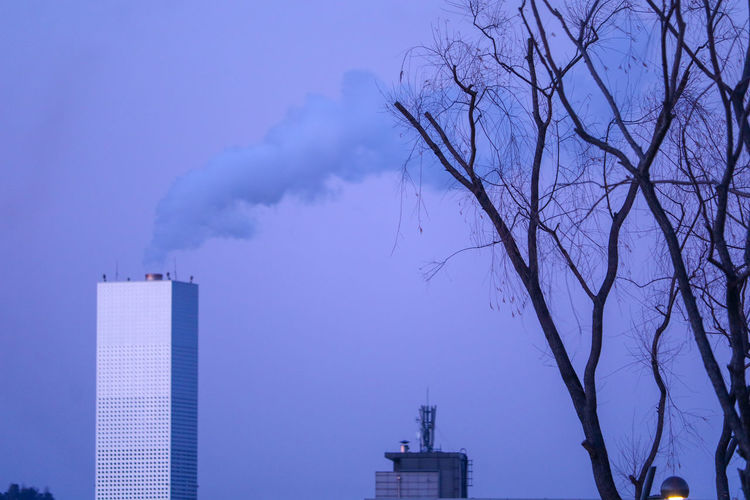 Smoke emitting from chimney against sky