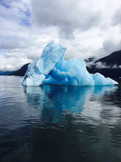 Iceberg on lake against sky