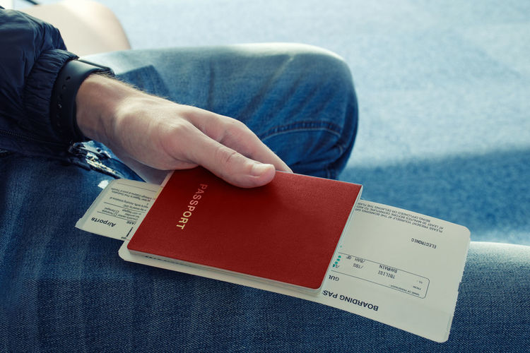 Midsection of man holding passport