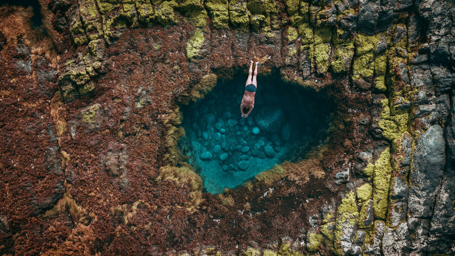 High angle view of shirtless man diving in sea against sky