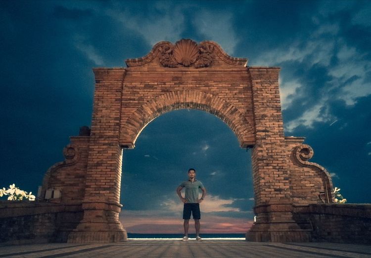 Man standing at historical building against sky