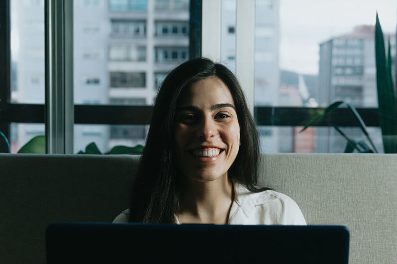 Portrait of smiling young businesswoman using laptop