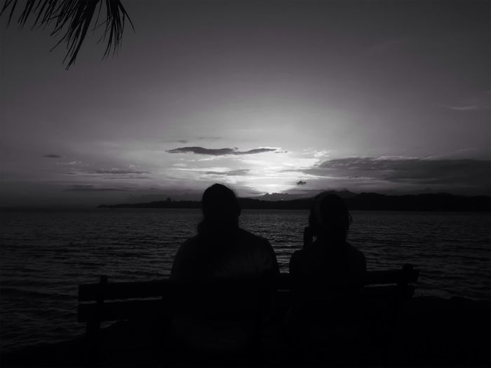 Silhouette of people sitting on beach