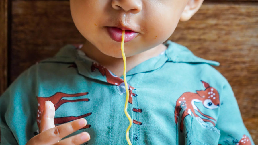 Close-up baby eating noodles