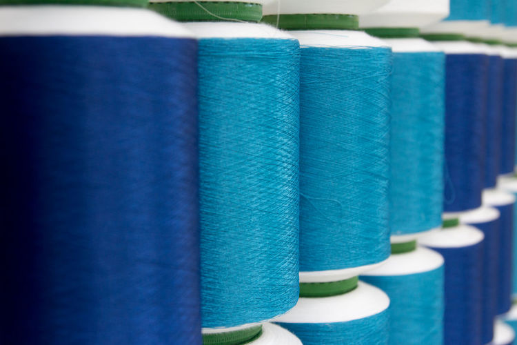 Close-up of blue thread spools in row