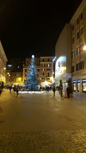 People in illuminated city at night