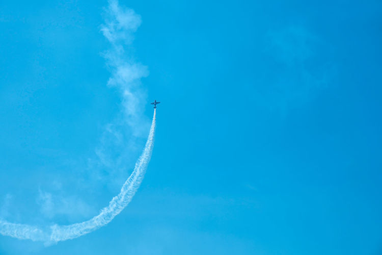 Overhead flying aircraft. aircraft in formation during an aerobatics display as they loop and roll