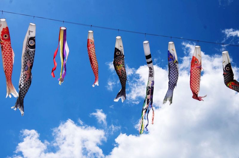 Low angle view of carp streamer against sky