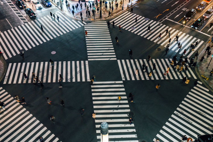 High angle view of people crossing road in city at night