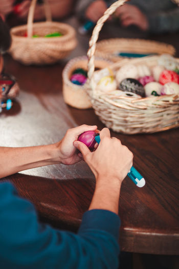 Cropped hands of woman cutting easter egg