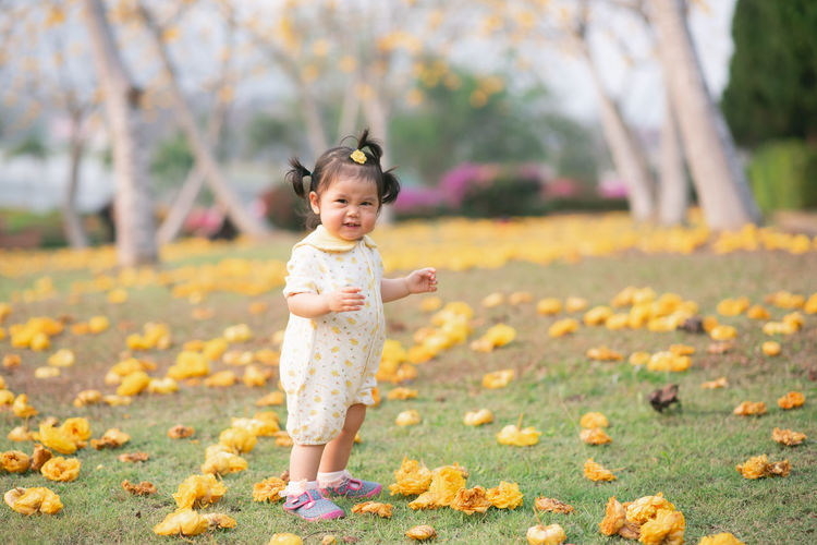 Portrait of cute baby girl standing on land