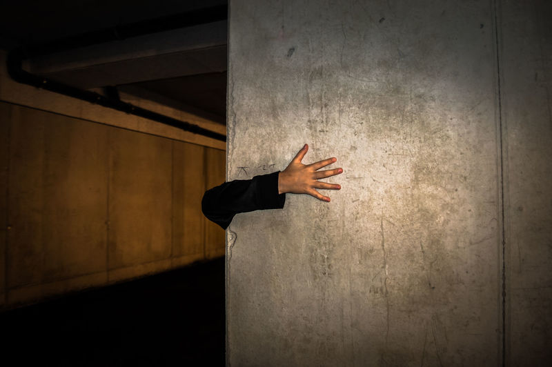 Close-up of man hand on pillar at subway station