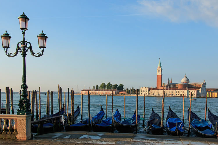 Gondola anchored by river overlooking basilica