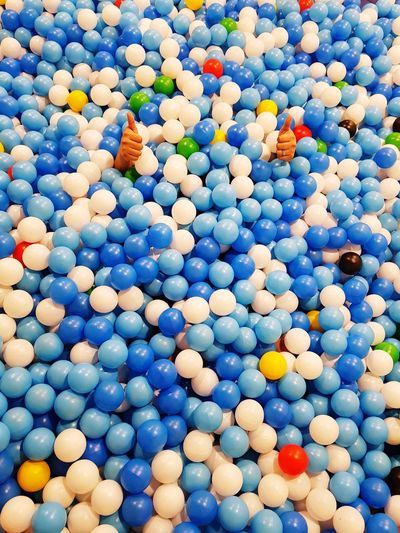 Full frame shot of ball pool with hands showing thumbs up sign