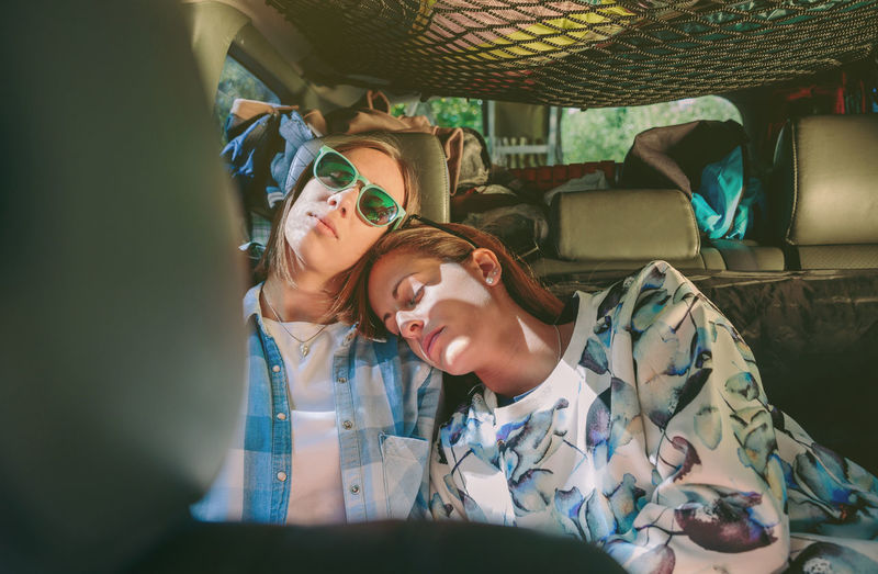 Female friends sleeping in car