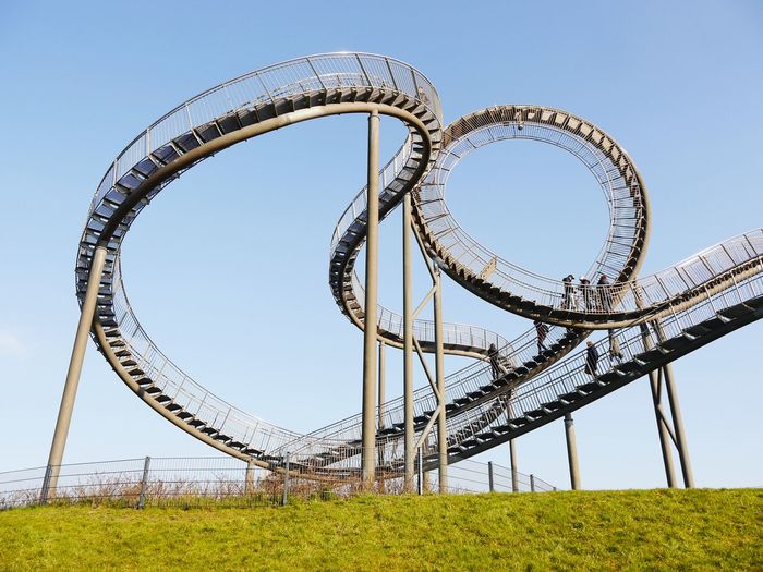 Low angle view of roller coaster tracks against clear sky