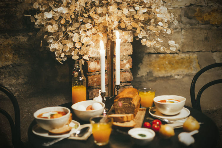 Close-up of shakshuka and fresh bread on table against wall