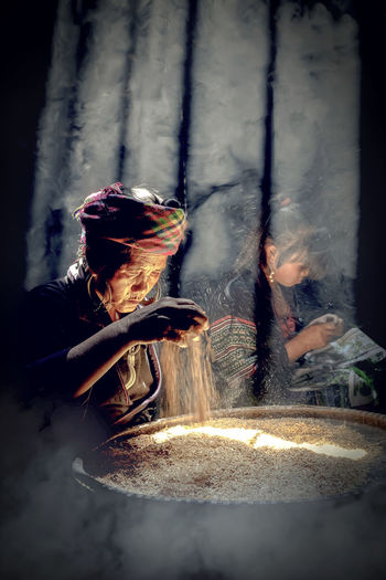 Mature woman cleaning grain at home