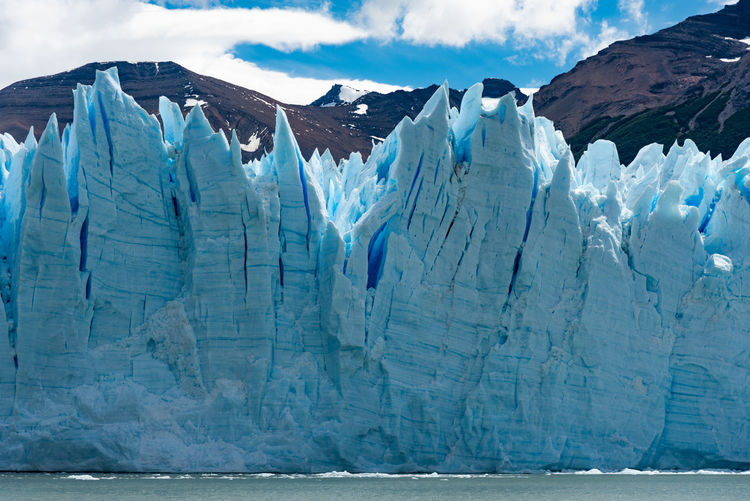 Scenic view of ice formations by sea against sky