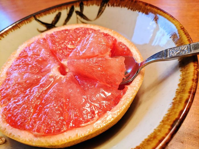 Close-up of grapefruit in plate on table