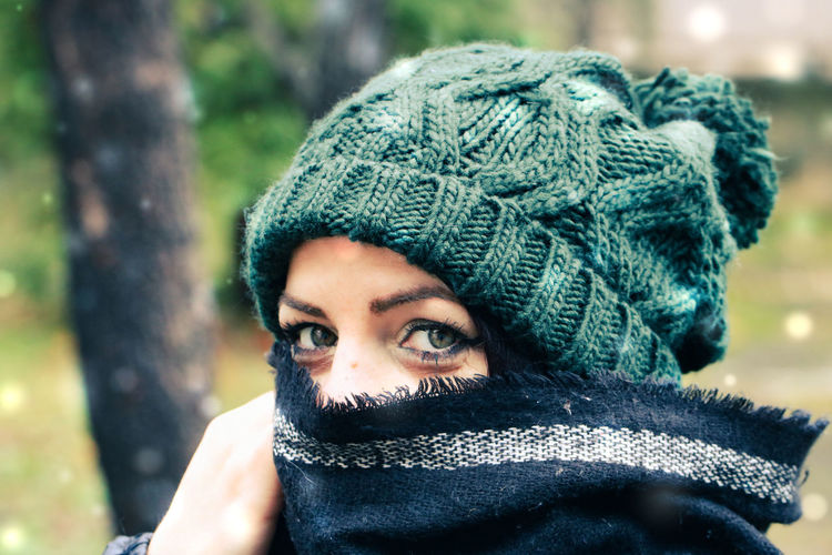 Close-up portrait of woman wearing knit hat standing outdoors