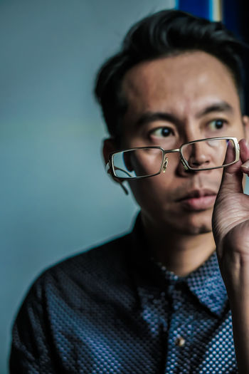 Thoughtful man with eyeglasses sitting at home