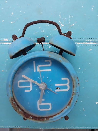 Close-up of clock on blue wall