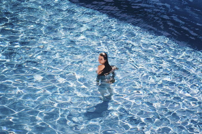YOUNG WOMAN SWIMMING IN POOL