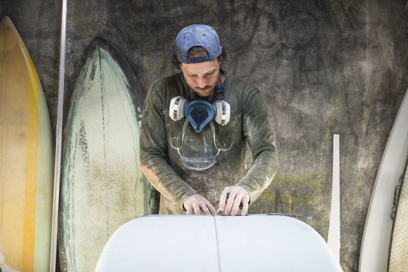Surfboard shaper measuring a new design