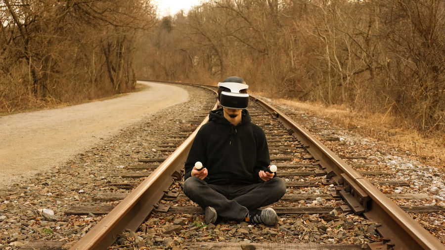 Man sitting on railroad track