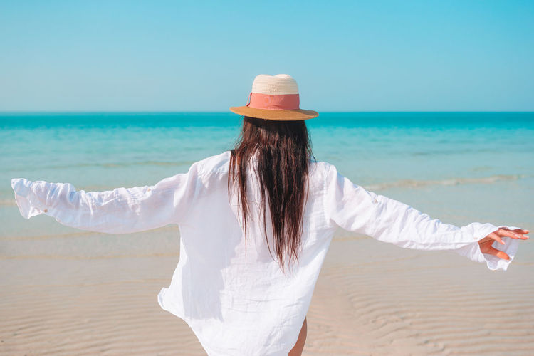 Rear view of woman standing on beach