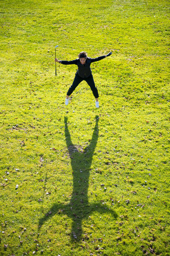 Shadow of person jumping on field