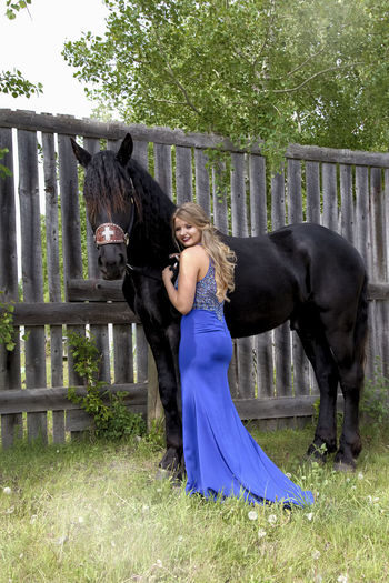 Portrait of woman embracing horse while standing outdoors