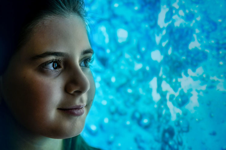 Close-up portrait of girl looking at water