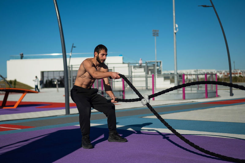 Full length of young man exercising in gym
