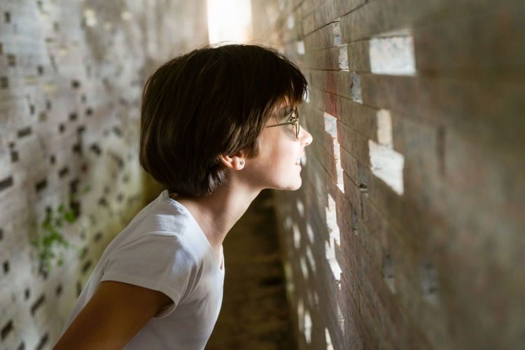Portrait of teenage girl standing against wall