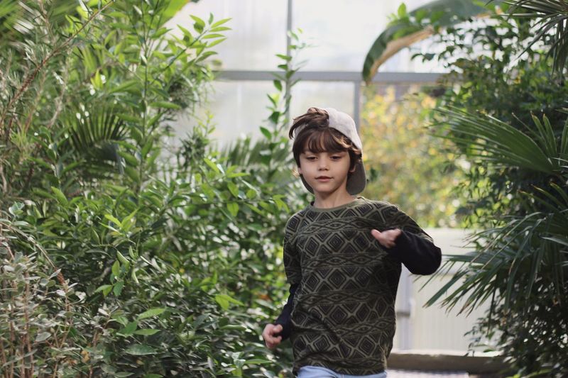Boy standing against plants