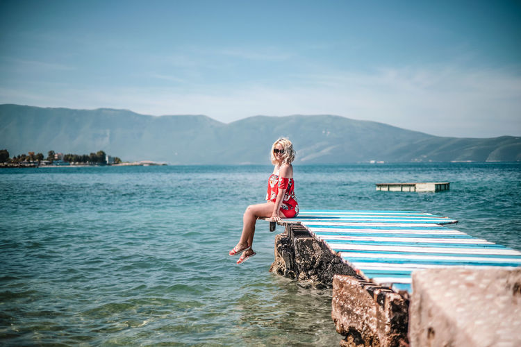 Full length of boy on sea against sky