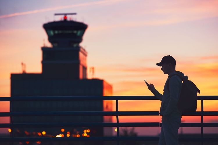Silhouette man standing against sky during sunset