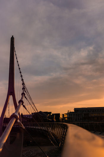 View of bridge over city against cloudy sky