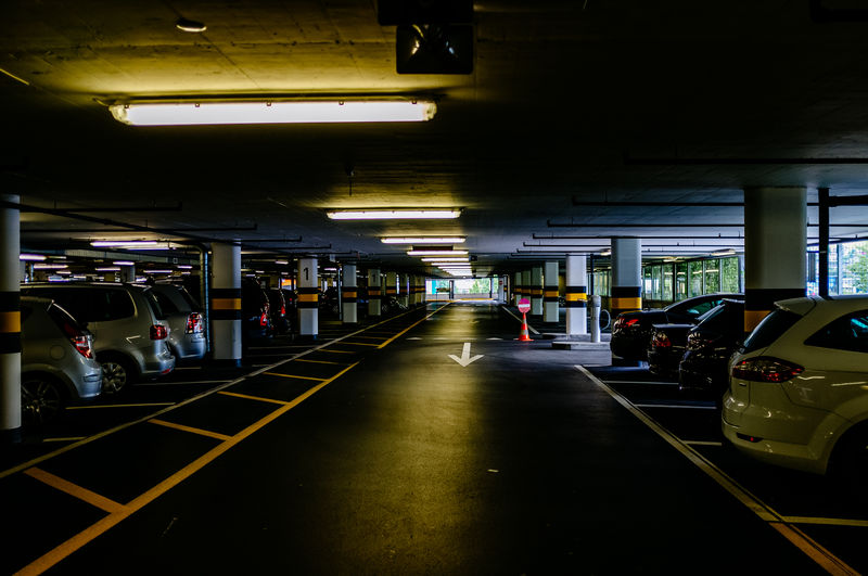 Empty driveway of illuminated parking lot