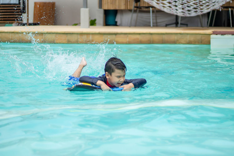 Full length of boy swimming in pool