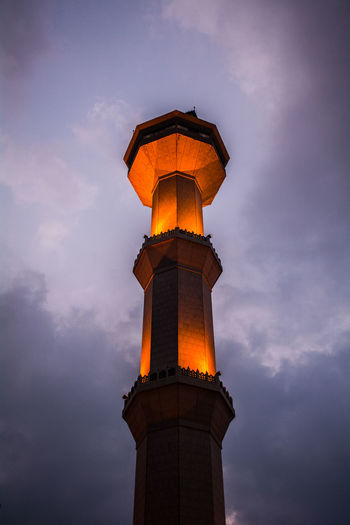 Low angle view of illuminated tower against sky during sunset