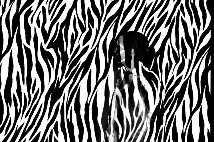 Digital composite image of woman against zebra print